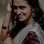 A woman in traditional Indian dress smiling outdoors in Ernakulam, Kerala.